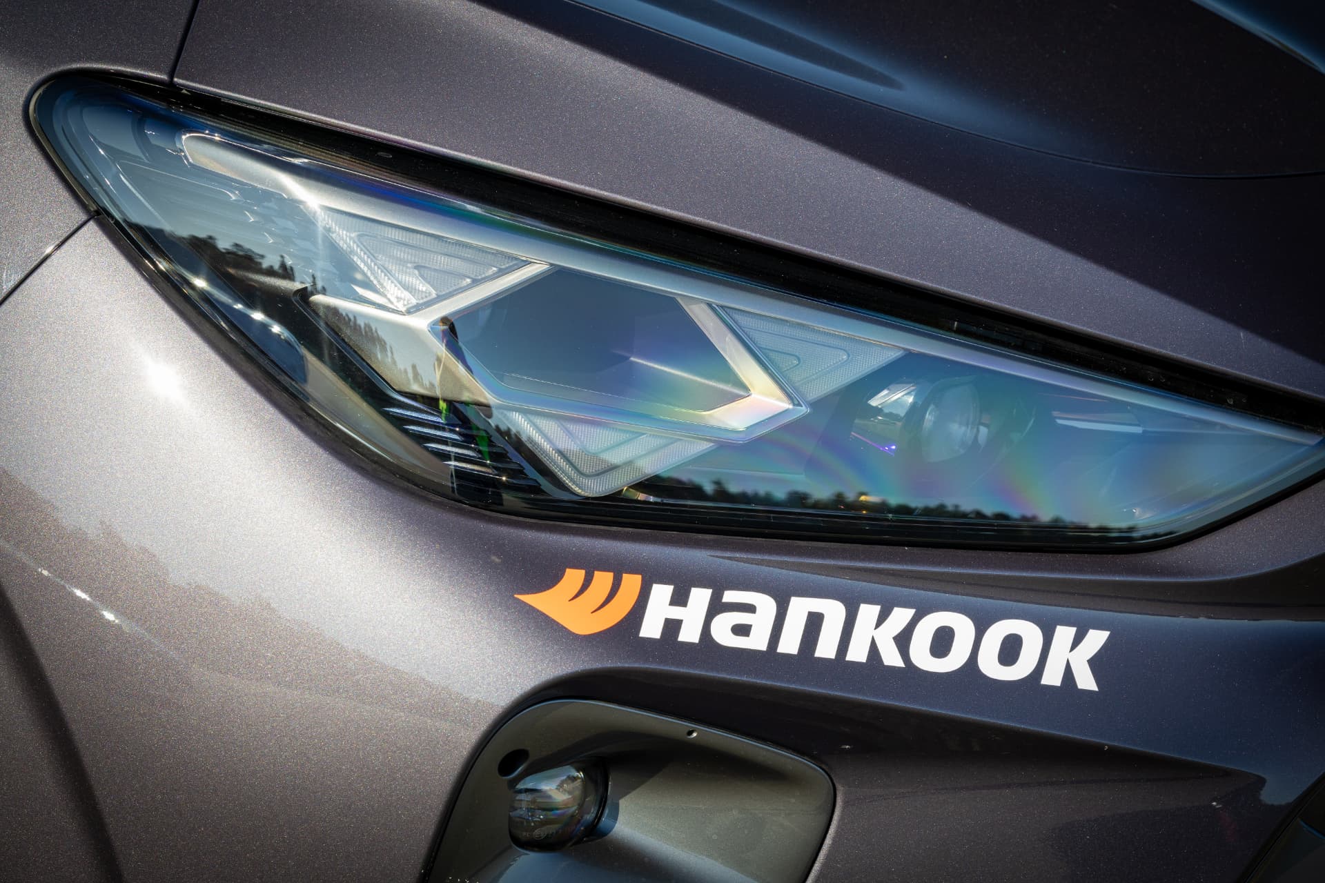 Närbild på bil med Hankook-dekal vid strålkastaren